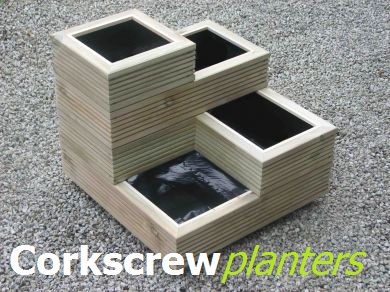 View corkscrew shaped wooden tower planters.